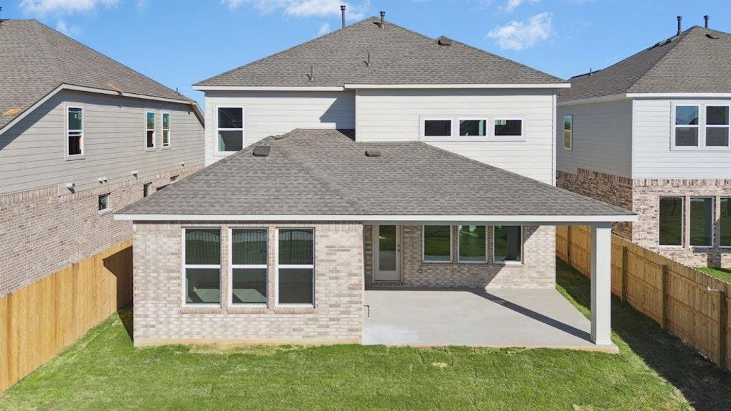 Rear view of house with a patio, roof with shingles, and a fenced backyard