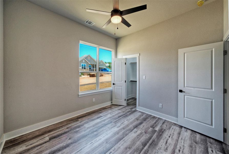 Gleaming wood-look floors, soaring ceilings, and a walk-in closet highlight this bedroom space. Gleaming wood-look floors, soaring ceilings, and a walk-in closet highlight this bedroom space.