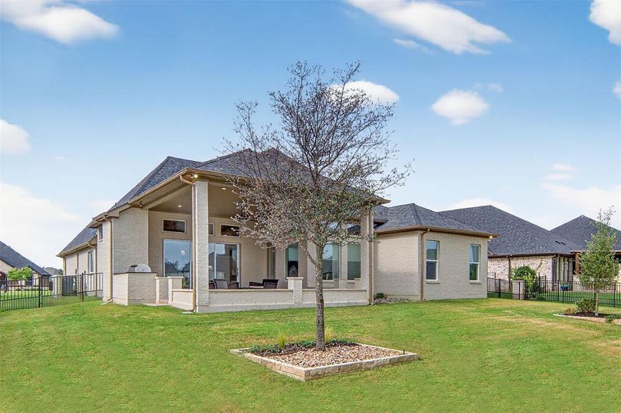 Back of property with a fenced backyard, brick siding, a patio area, and a ceiling fan