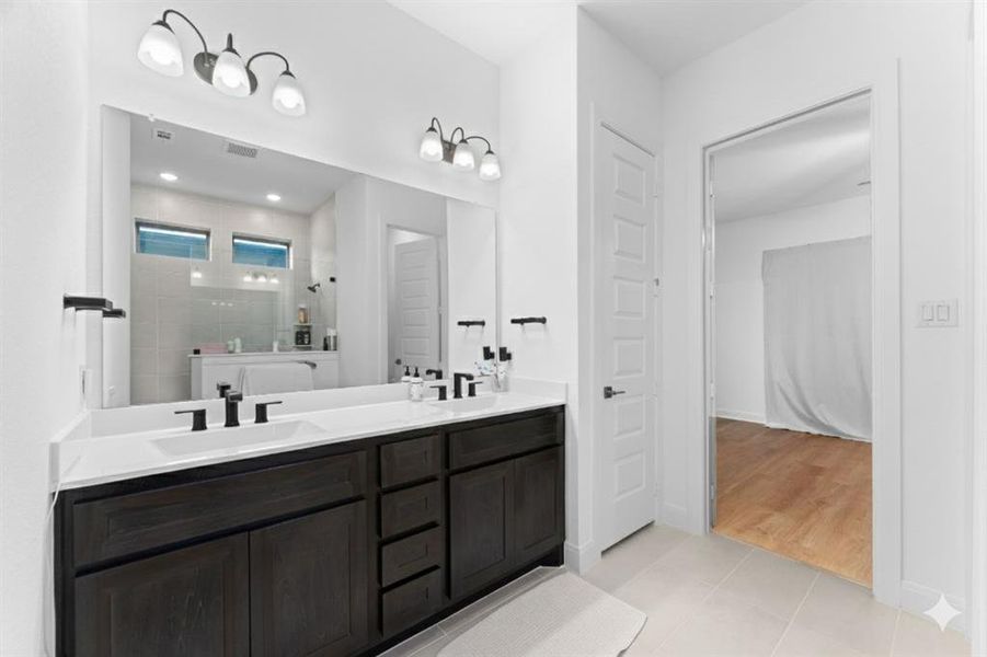 Bathroom with double vanity, a walk in shower, and light tile patterned floors Bathroom with double vanity, a walk in shower, and light tile patterned floors