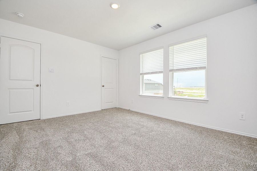 This photo shows a bright, carpeted room with neutral walls. It features two large windows with blinds, providing natural light. There's a door and a closet, making it suitable as a bedroom or office. This photo shows a bright, carpeted room with neutral walls. It features two large windows with blinds, providing natural light. There's a door and a closet, making it suitable as a bedroom or office.