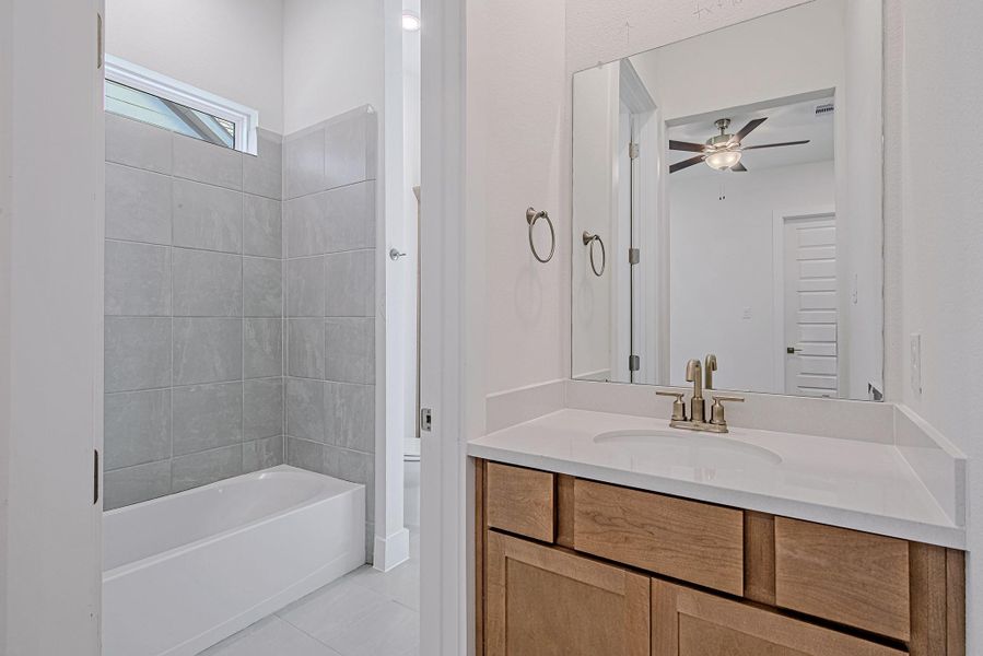 Full bathroom with vanity and shower/tub combination.