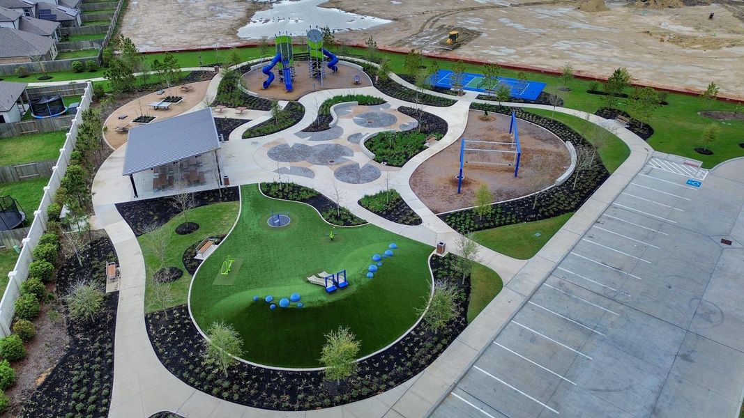 Beautiful neighborhood park featuring a playground, open green spaces, shaded seating areas, walking paths, and recreational courts—perfect for outdoor activities, family gatherings, and enjoying the community amenities just minutes from the home.