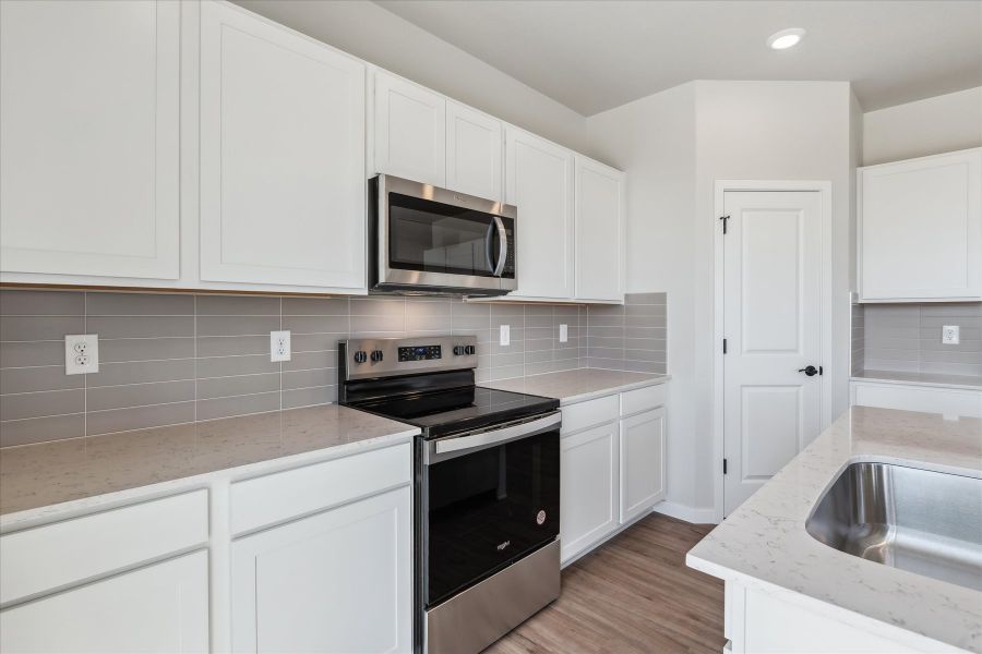 A kitchen with white cabinets.