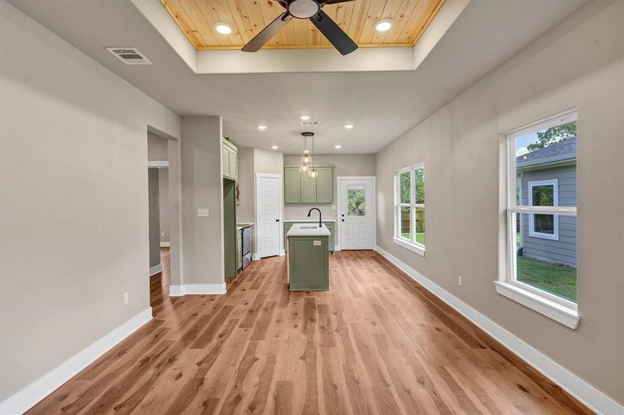 Kitchen with green cabinetry, a raised ceiling, recessed lighting, light wood-style flooring, and ceiling fan Kitchen with green cabinetry, a raised ceiling, recessed lighting, light wood-style flooring, and ceiling fan
