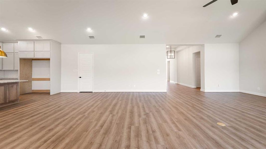 Unfurnished living room with light hardwood / wood-style floors and ceiling fan