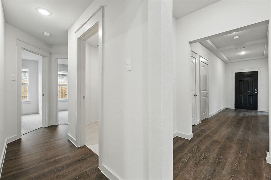 Hallway featuring dark wood-type flooring and recessed lighting Hallway featuring dark wood-type flooring and recessed lighting