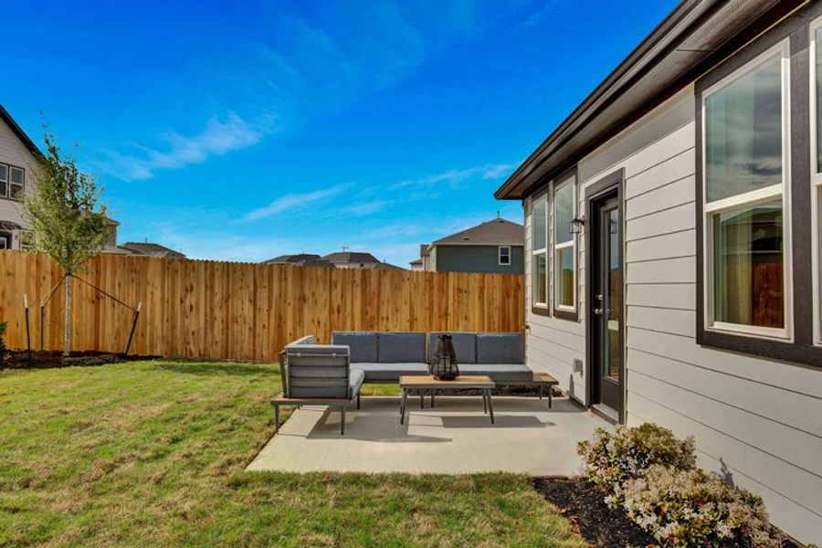 A backyard with a fence and a table and chairs. A backyard with a fence and a table and chairs.