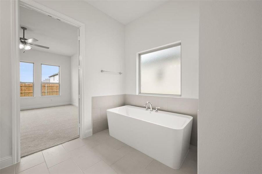 Bathroom featuring a freestanding bath, a ceiling fan, and tile patterned floors Bathroom featuring a freestanding bath, a ceiling fan, and tile patterned floors