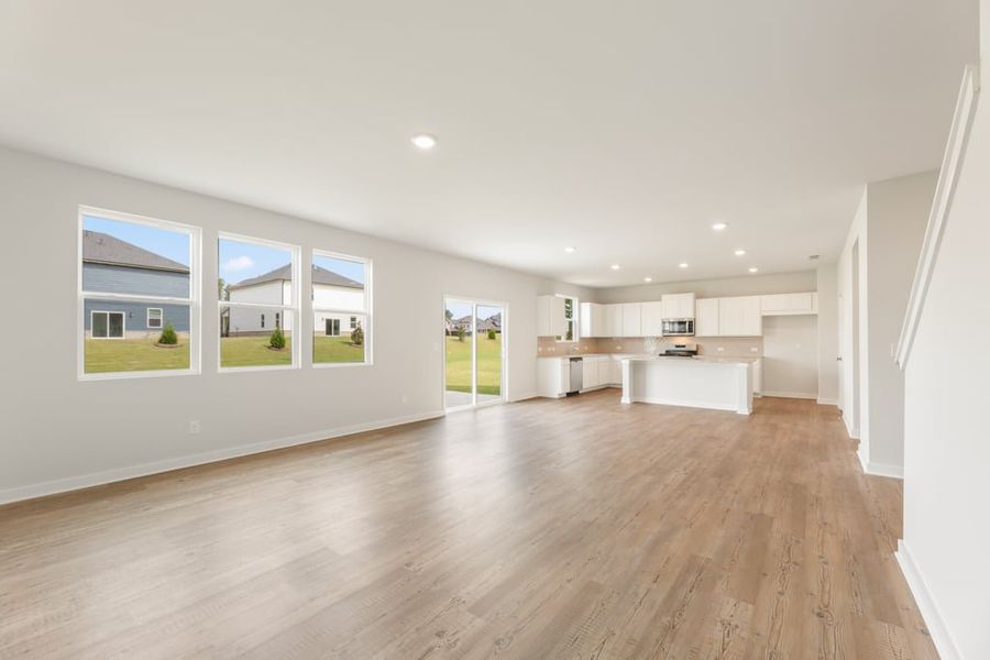 A large empty room with a wood floor and white walls. A large empty room with a wood floor and white walls.