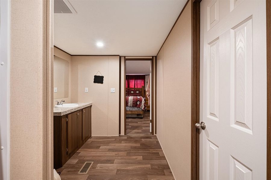 Hall featuring dark wood finished floors and a sink