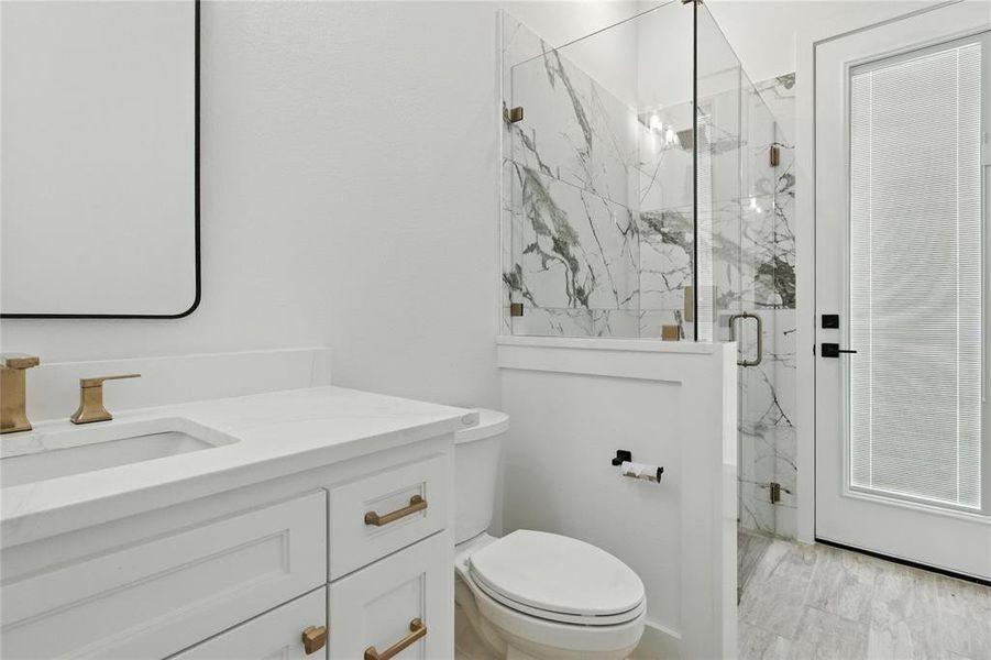 Full bathroom featuring a marble finish shower and vanity