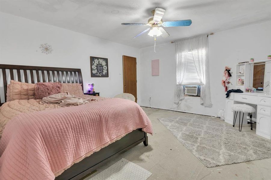 Bedroom with unfinished concrete floors and ceiling fan Bedroom with unfinished concrete floors and ceiling fan