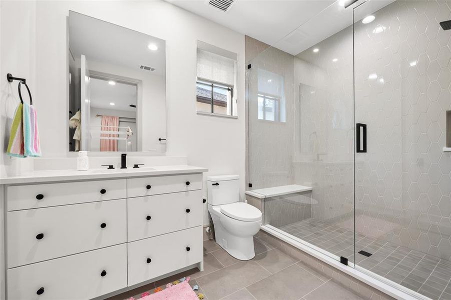 Bathroom featuring vanity, shower, light tile patterned floors, and recessed lighting