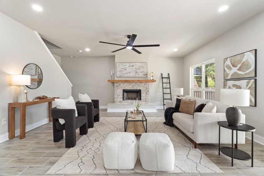A striking stone fireplace and a dark-bladed ceiling fan define this inviting living area. A striking stone fireplace and a dark-bladed ceiling fan define this inviting living area.