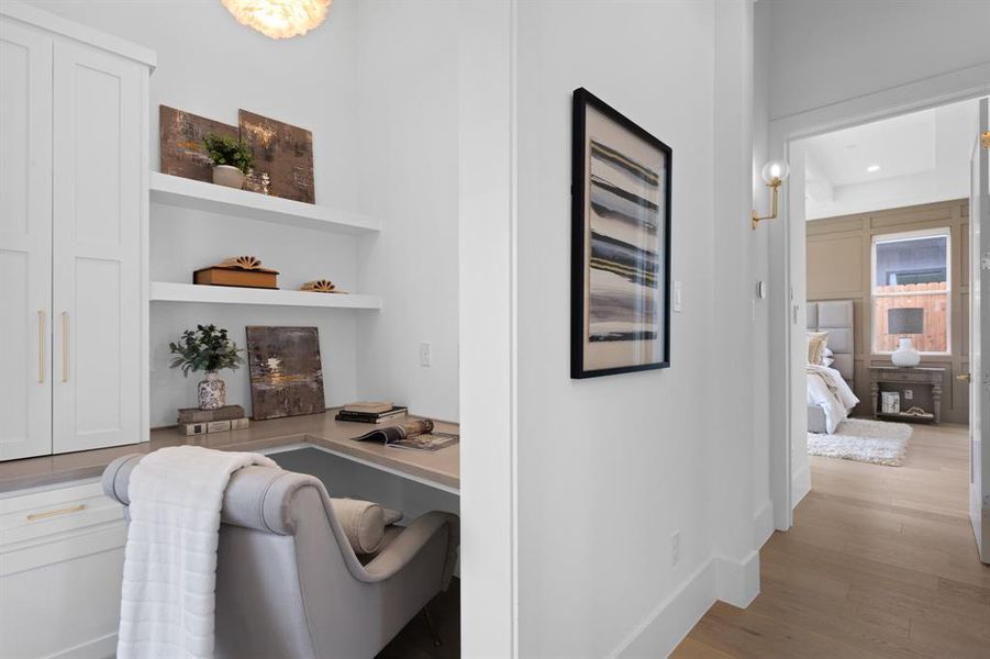 Corridor featuring light hardwood flooring, an office area with built in custom cabinets and desk area, recessed lighting, and baseboards. Custom features throughout! Corridor featuring light hardwood flooring, an office area with built in custom cabinets and desk area, recessed lighting, and baseboards. Custom features throughout!