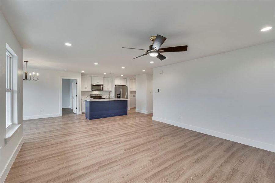 Unfurnished living room featuring light wood-style floors, recessed lighting, and baseboards