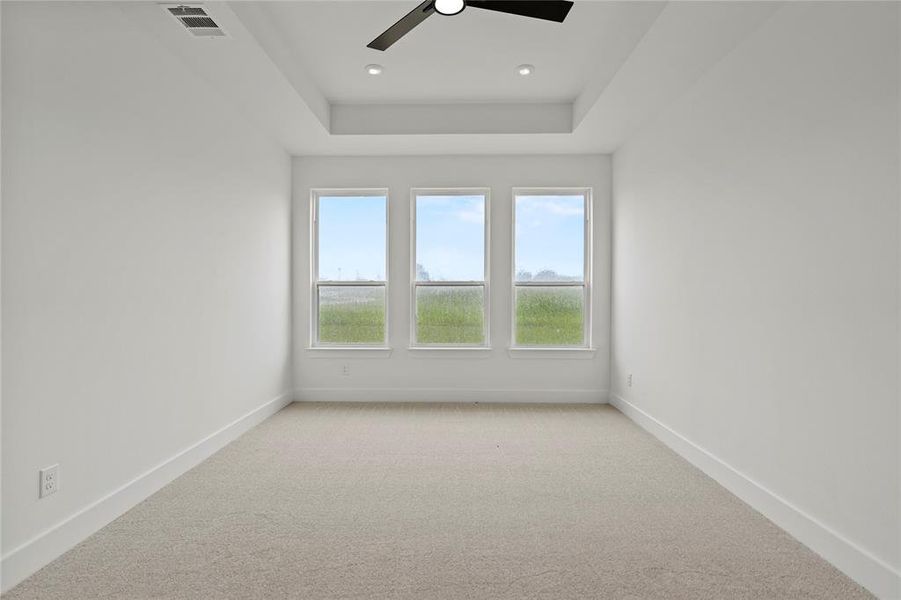Spare room featuring light carpet, a ceiling fan, a raised ceiling, and recessed lighting Spare room featuring light carpet, a ceiling fan, a raised ceiling, and recessed lighting