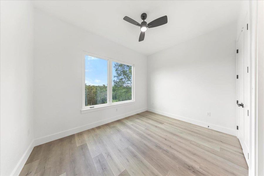 Empty room featuring light wood-style flooring and ceiling fan Empty room featuring light wood-style flooring and ceiling fan