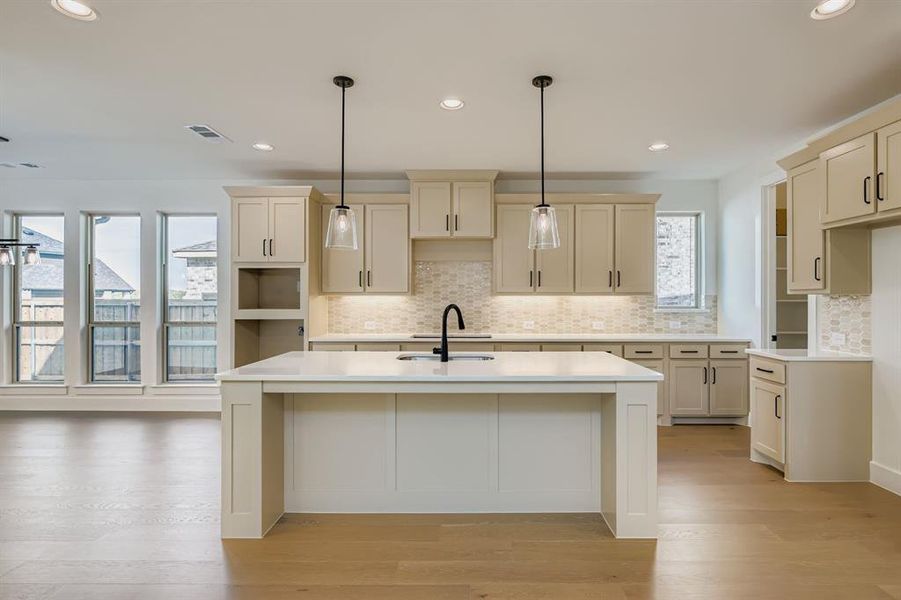 Kitchen featuring decorative backsplash, pendant lighting, recessed lighting, an island with sink, and a breakfast bar Kitchen featuring decorative backsplash, pendant lighting, recessed lighting, an island with sink, and a breakfast bar