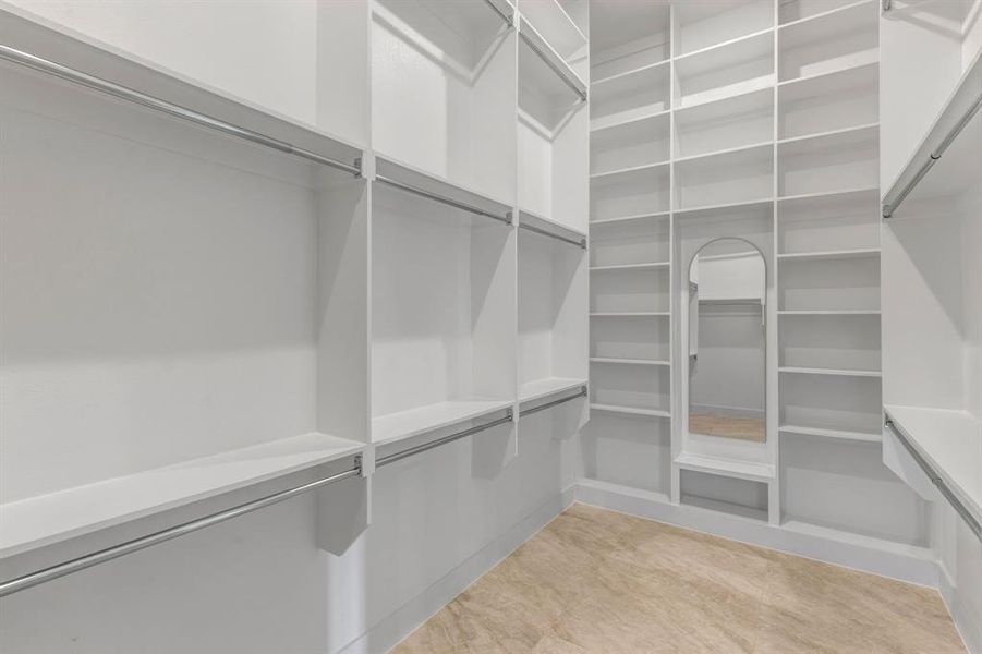 View of primary custom spacious closet with 12' ceilings