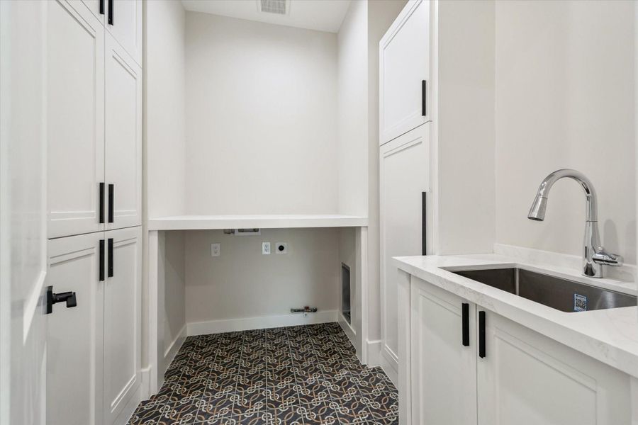 This Utility room showcases decorative tile floor, quartz countertops, a large stainless sink, and sleek cabinetry. Ample built-ins make it as functional as it is stylish. This Utility room showcases decorative tile floor, quartz countertops, a large stainless sink, and sleek cabinetry. Ample built-ins make it as functional as it is stylish.