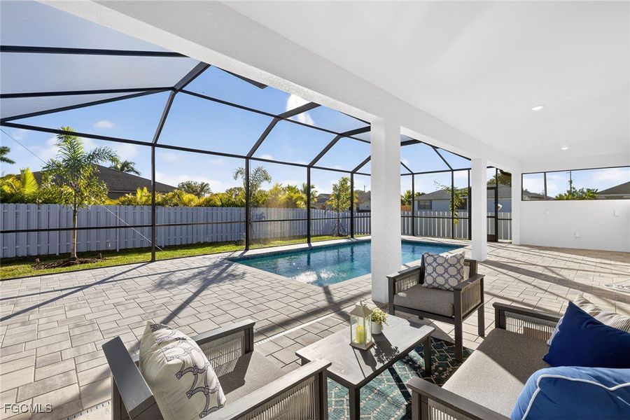 View of swimming pool with a sunroom, glass enclosure, a patio, a fenced backyard, and an outdoor living space