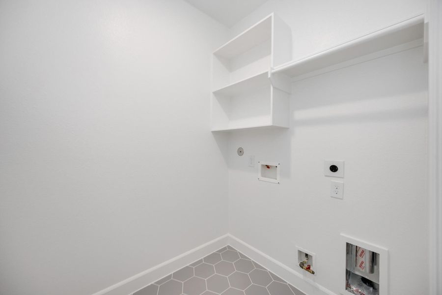 Clean design meets clever function in this dedicated laundry room. With built-in shelving and plenty of space to fold, it actually makes chores feel…doable.