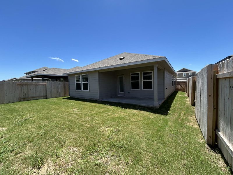 Rear view of house with a fenced backyard, a patio area, and a shingled roof Rear view of house with a fenced backyard, a patio area, and a shingled roof
