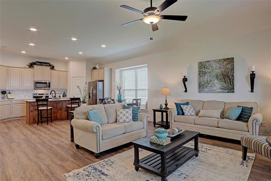 Living room featuring ceiling fan, light hardwood / wood-style floors, and sink