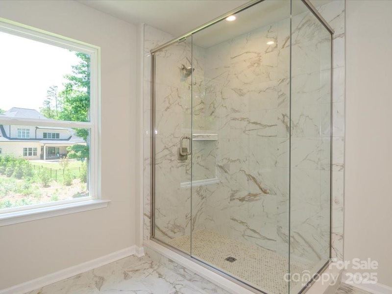 Walk-in glass framed shower with modern oversized wall tile. Walk-in glass framed shower with modern oversized wall tile.