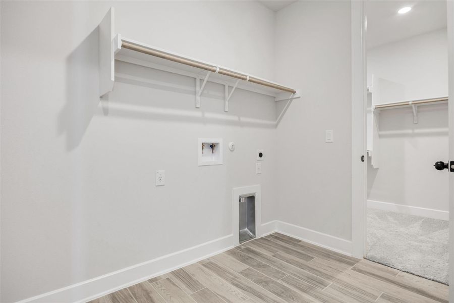 Laundry area featuring hookup for a gas dryer, light wood finished floors, washer hookup, and hookup for an electric dryer