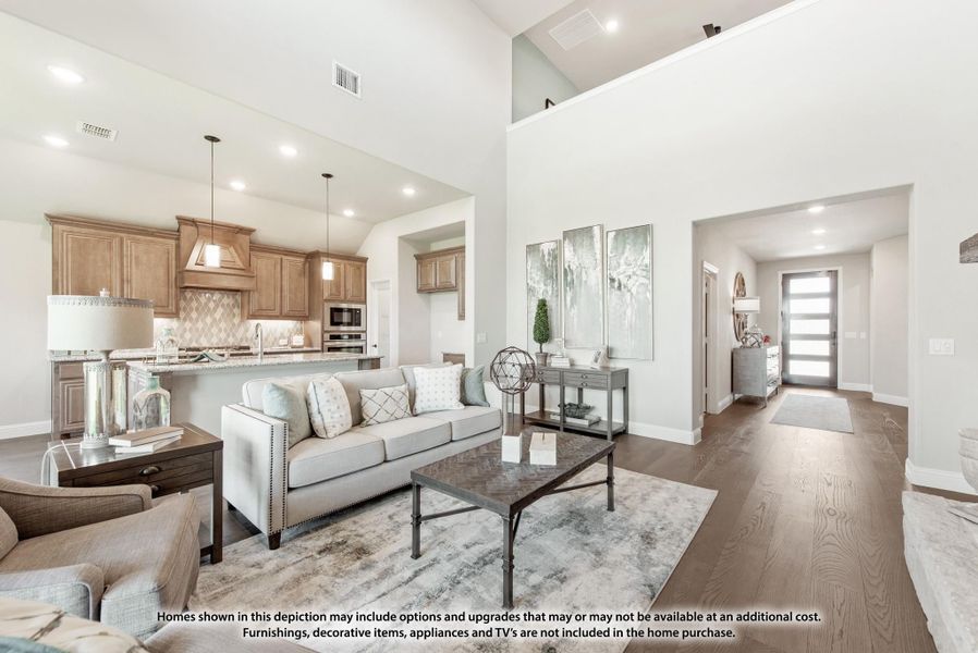 Open-concept living room and kitchen with high ceilings, hardwood floors, and wood cabinetry Open-concept living room and kitchen with high ceilings, hardwood floors, and wood cabinetry