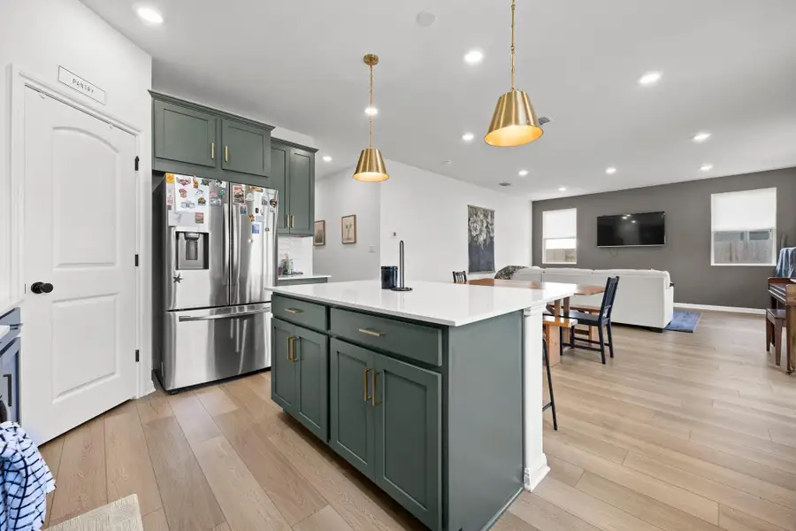 Modern kitchen featuring a central island with a white countertop and recessed panel cabinetry