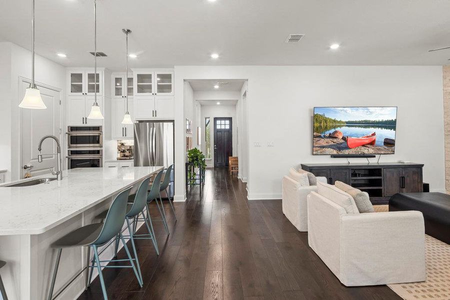 Living room featuring recessed lighting, visible vents, dark wood-style flooring, and baseboards