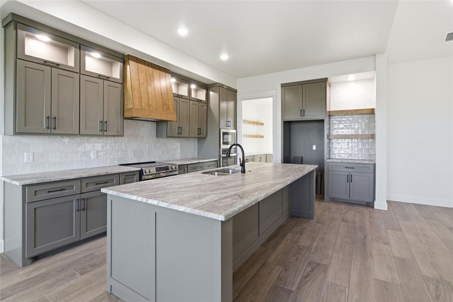 A well-appointed kitchen features a spacious island with a sink and ample cabinet storage. A well-appointed kitchen features a spacious island with a sink and ample cabinet storage.