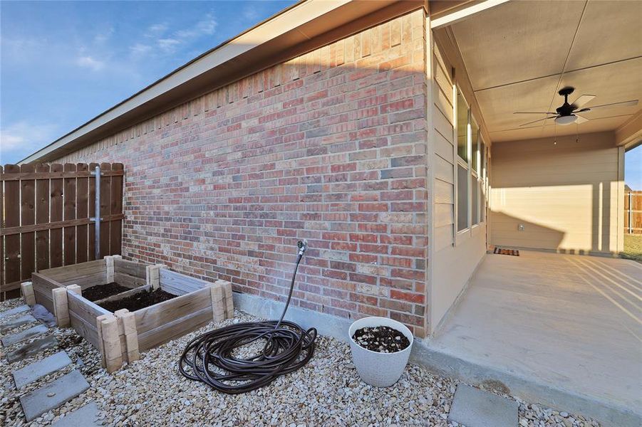 Garden boxes at side of house are set in a landscaped rock base with foot path, for easy access and mud-free gardening shoes.