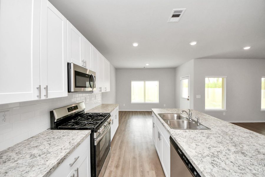 White kitchen with handles and brand new stainless steel appliances