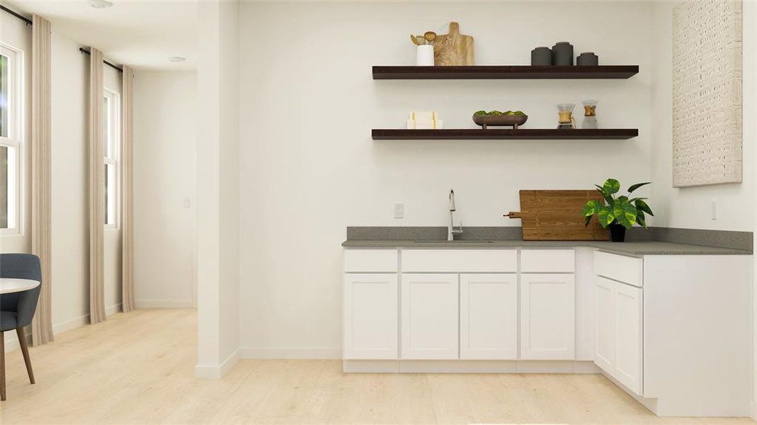 Indoor wet bar with white cabinets, light wood-style flooring, open shelves, and dark stone countertops