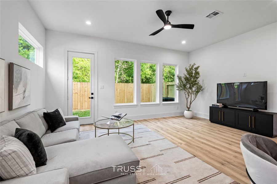 Framed by expansive windows, the living area feels airy and connected, designed to maximize both sunlight and spatial flow.