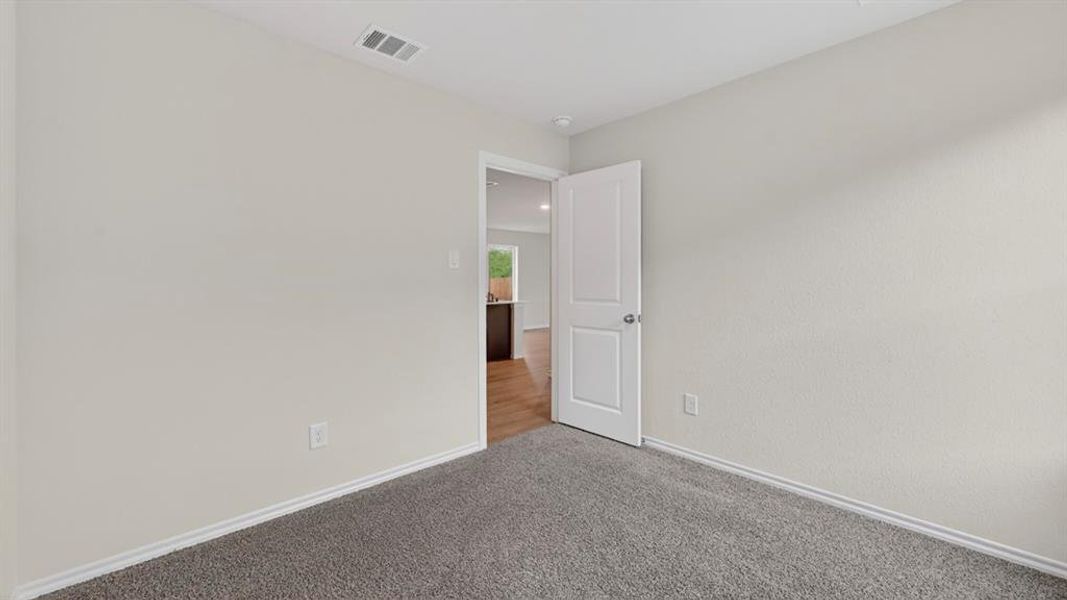 Neutral tone walls with white trim and gray carpeting