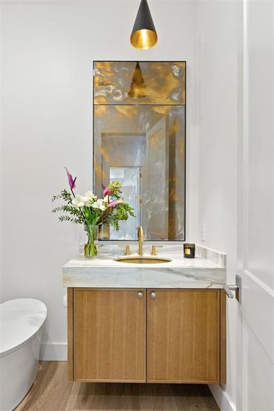 Half bathroom featuring vanity and wood finished floors