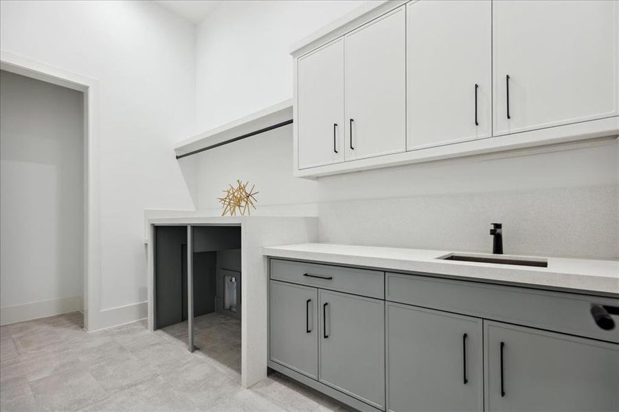 Washroom featuring sink and light tile floors