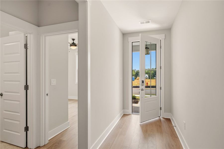 A welcoming entry corridor features elegant wood f