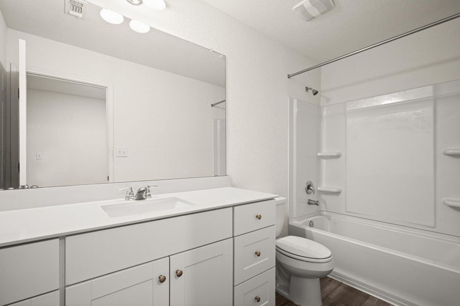 Full bath with bathing tub / shower combination, vanity, and dark wood-style floors