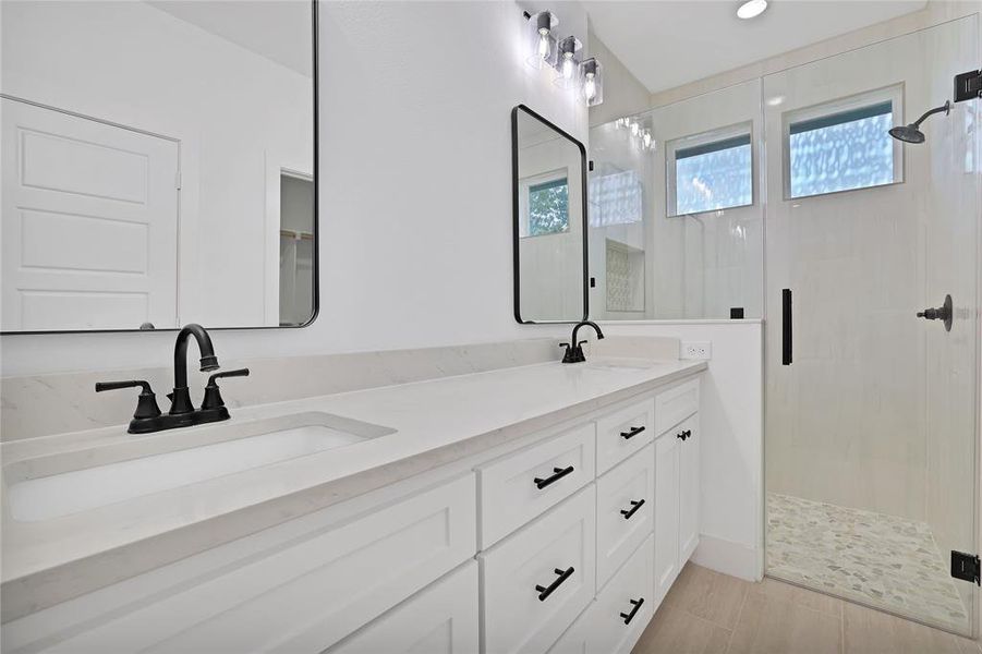 Primary Bathroom with walk in shower and dual vanity.