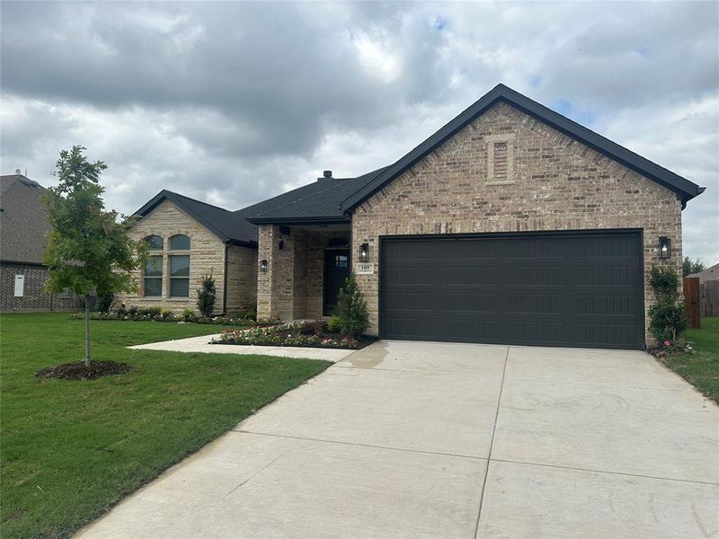 View of front of house featuring a garage and a front yard