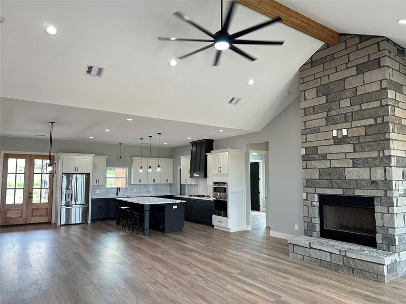 Upon entry: open floor plan, vaulted ceiling, woodburning fireplace.