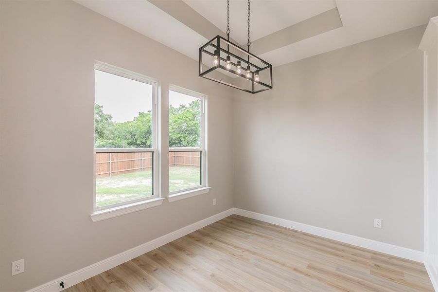 Unfurnished dining area with a chandelier, baseboards, and light wood-type flooring Unfurnished dining area with a chandelier, baseboards, and light wood-type flooring