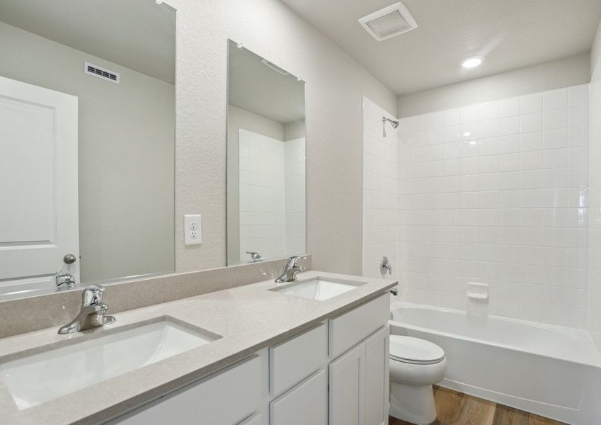 The secondary bathroom has a dual sink vanity and a tub/shower combo.